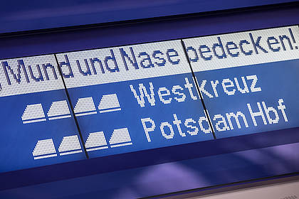 Hinweis zur Maskenpflicht an Bahnhofsanzeige 